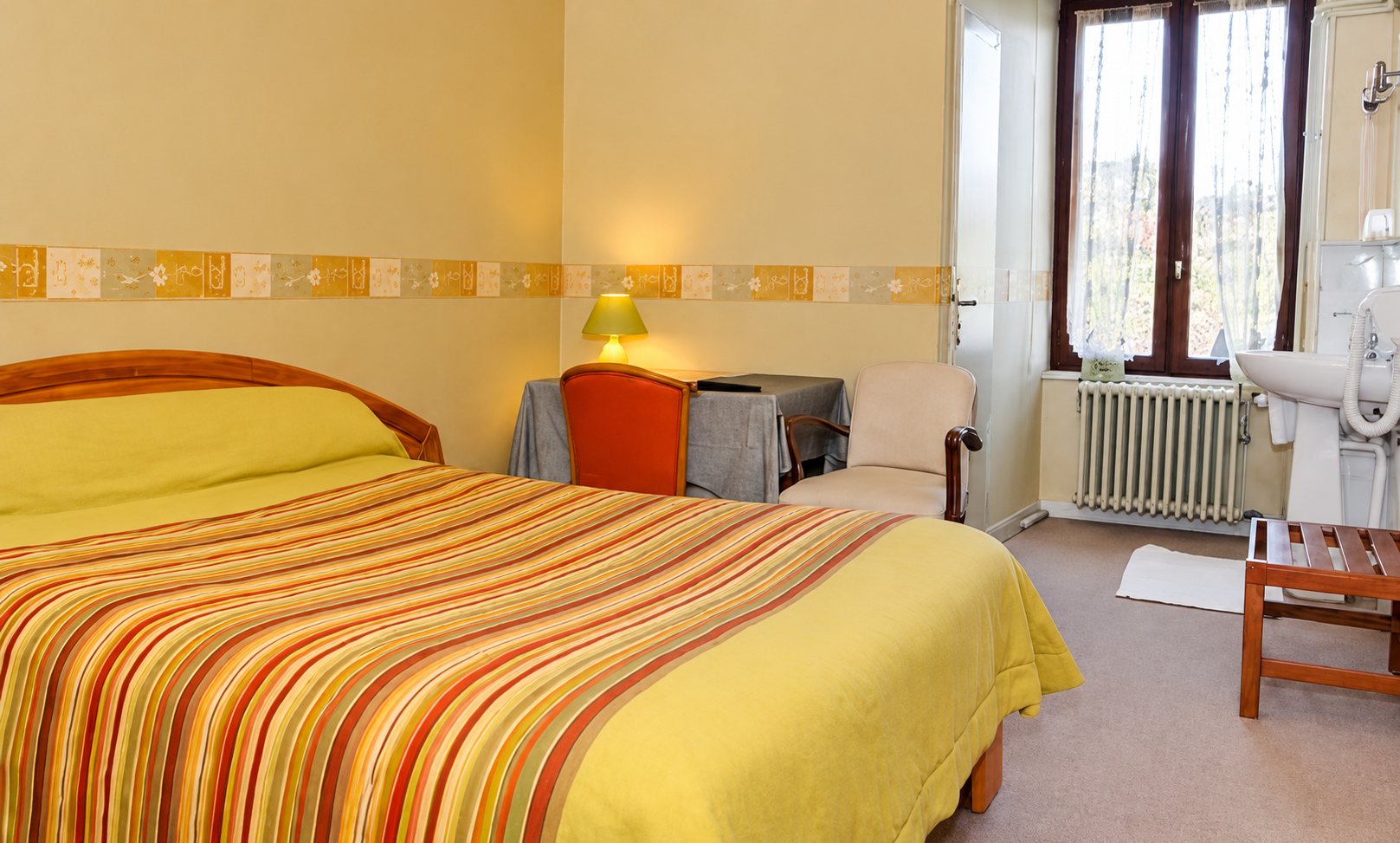 Chambre avec lit à rayures jaunes et orange