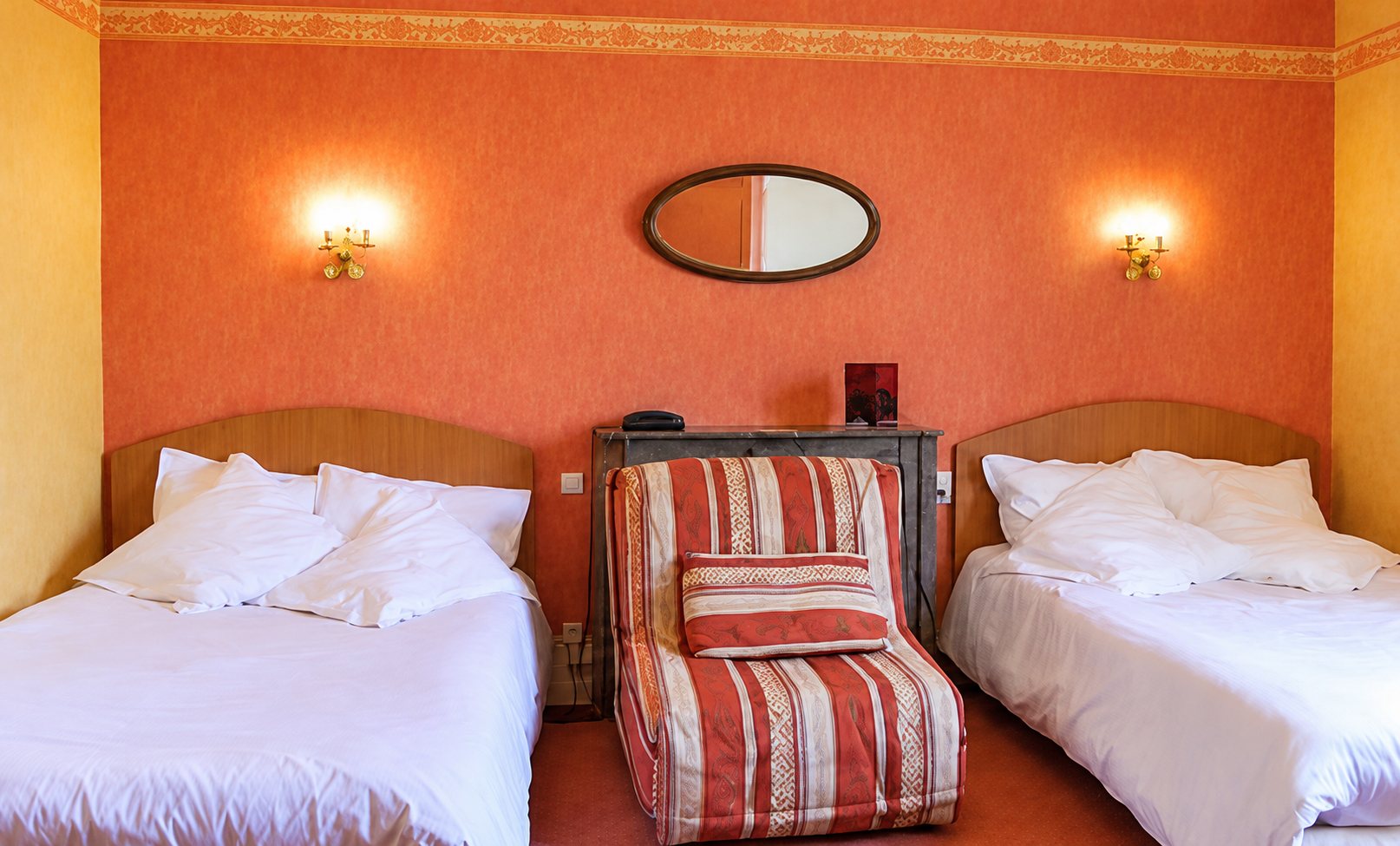 Chambre aux murs orange avec deux lits