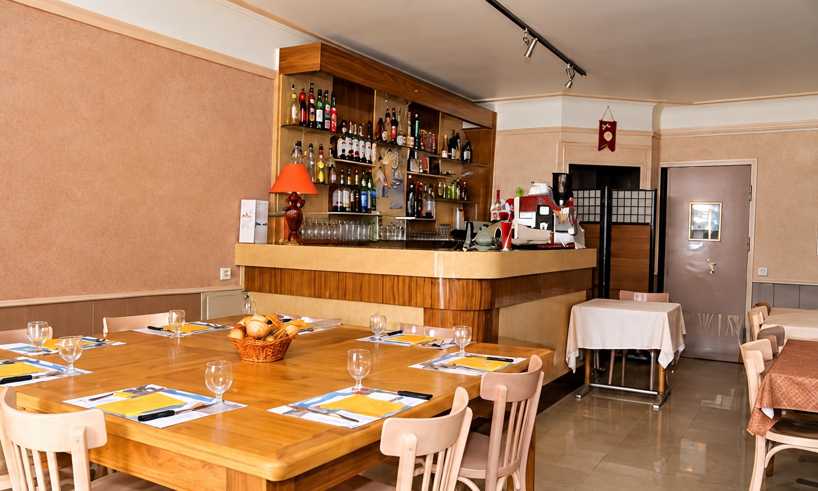 Salle de restaurant avec comptoir et tables dressées